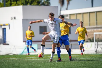 Danil Ankudinov protege el bal&oacute;n ante un jugador del Tomares