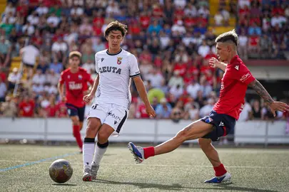 Gonzalo Guzm&aacute;n golpea el bal&oacute;n ante un jugador del Dos Hermanas