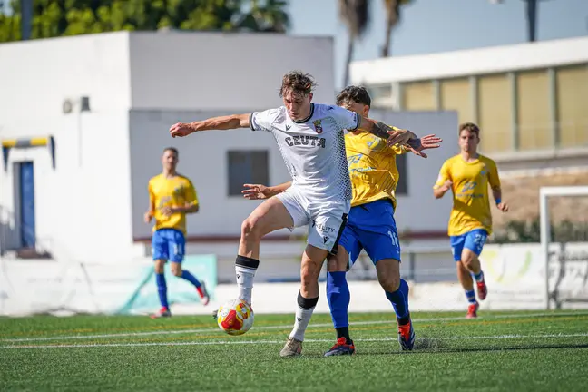 Danil Ankudinov protege el bal&oacute;n ante un jugador del Tomares