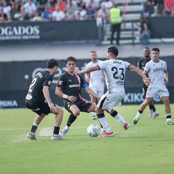 Anuar golpea el balón ante dos jugadores del Sporting