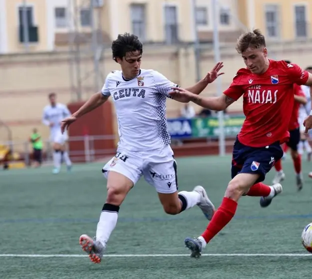 Guzm&aacute;n corre con un rival durante el partido de este s&aacute;bado