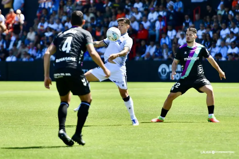 Kuki Zalazar control el bal&oacute;n ante dos jugadores malaguistas