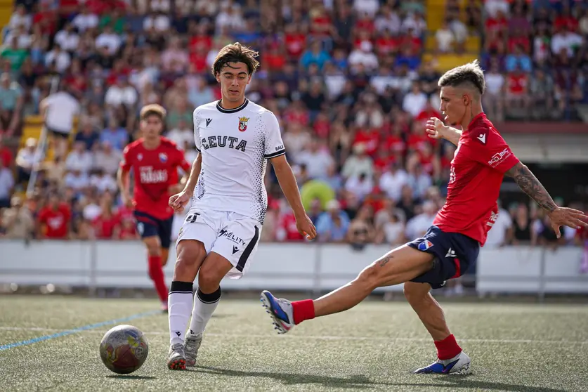 Gonzalo Guzm&aacute;n golpea el bal&oacute;n ante un jugador del Dos Hermanas