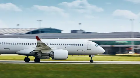 Passenger airplane accelerates on airport runway for take off.