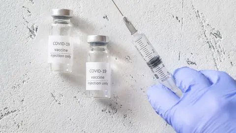 Doctor withdrawing medication from Coronavirus vaccine tube