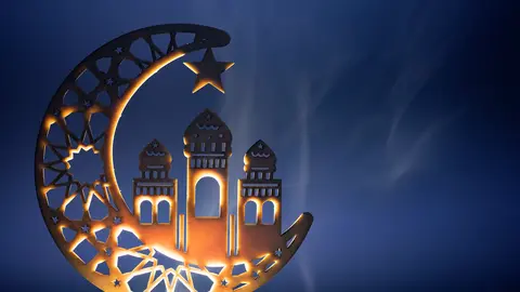 Ornamental Arabic decoraion with burning candle glowing at night and glittering golden bokeh lights. Festive greeting card for Muslim holy month Ramadan Kareem.