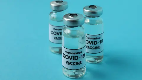Vials of Covid - 19 vaccine on blue background