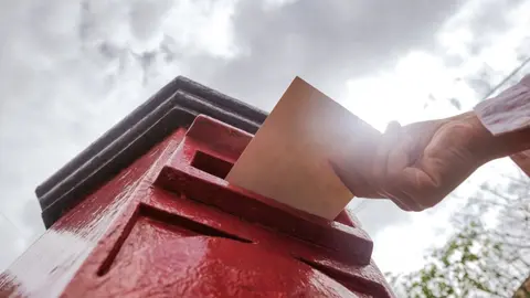 closeup-on-a-male-hand-putting-a-letter-in-a-red-l-2022-05-24-08-12-33-utc (1)