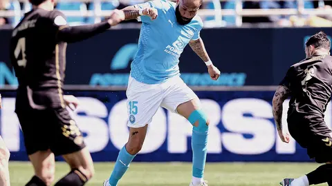 El delantero del Ibiza Bebé, entre dos jugadores del Intercity