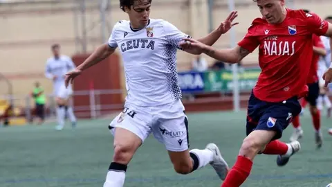 Guzm&aacute;n corre con un rival durante el partido de este s&aacute;bado