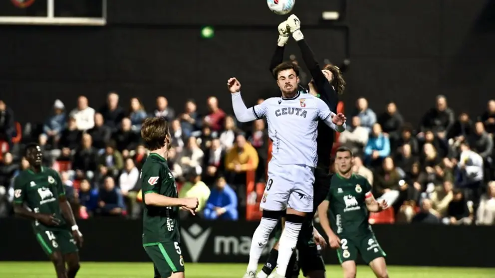 Marcos Fern&aacute;ndez salta con el portero del Racing